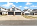 Charming townhouses with gray garages, stone accents, and white siding offer curb appeal at 10744 Eldorado Cir, Noblesville, IN 46060