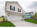 Charming two-story home showcases a two-car garage and a spacious driveway at 1265 Fleming Dr, Greenfield, IN 46140