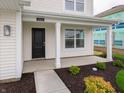 Inviting front porch with white columns, a black door, and decorative landscaping at 1265 Fleming Dr, Greenfield, IN 46140