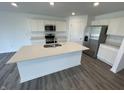 Modern kitchen featuring white cabinets, stainless steel appliances, and a spacious island with a sink at 1265 Fleming Dr, Greenfield, IN 46140