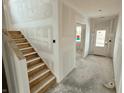 Spacious home entrance featuring staircase with unfinished walls and cement floors at 1618 Trichel Dr, Greenwood, IN 46143