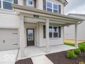 Inviting covered porch featuring white columns and stylish front door at 1618 Trichel Dr, Greenwood, IN 46143