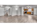 Open-concept living room featuring hardwood floors and direct access to the kitchen at 2011 Blue Pine Ln, Indianapolis, IN 46231