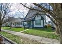 Traditional home with a cozy front porch and a neatly manicured lawn and sidewalk at 2432 N Talbott St, Indianapolis, IN 46205
