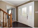 Inviting entryway with dark wood floors, a staircase with wooden railings, and a decorative glass front door at 3029 Oberlin Ct, Indianapolis, IN 46268