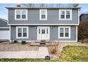 Charming two-story home features a tidy front lawn, stone walkway, and a decorative glass front door at 3029 Oberlin Ct, Indianapolis, IN 46268