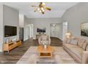 Bright living room with hardwood floors, neutral paint, ceiling fan, and comfortable furnishings at 307 Beacon Point Ln, Fortville, IN 46040