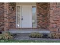 Close-up of the front door showcasing the brick facade and modern exterior lighting at 3705 River Rd, Columbus, IN 47203
