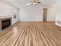 Spacious living room featuring a fireplace, vaulted ceiling, and bright, newly finished light hardwood floors at 3936 Par Dr, Indianapolis, IN 46268