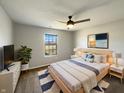 Comfortable bedroom with neutral tones, ceiling fan, and a view of the outdoors at 3951 Narrowleaf Ct, Indianapolis, IN 46235