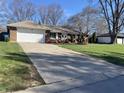 Charming brick home featuring an attached garage and long driveway situated on a well-maintained lawn at 4252 Bittersweet Ln, Greenwood, IN 46142