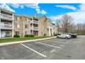 Apartment building with balconies and tan siding, enhanced by green space and a parking area at 4925 Opal Ridge Ln # 309, Indianapolis, IN 46237