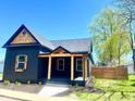 Charming home featuring dark siding, wooden accents, a covered porch, and a manicured lawn at 511 N Clark St, Lebanon, IN 46052