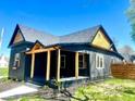 Charming home featuring dark siding, wooden accents, a covered porch, and a neatly trimmed lawn at 511 N Clark St, Lebanon, IN 46052