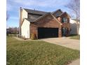 Two-story home with brick and vinyl siding, a two-car garage, and a lush green lawn at 6812 Cadwell Cir, Indianapolis, IN 46237