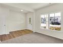 Bright living space with carpet and wood flooring, offering ample natural light through a large window at 7152 Jackson Dr, Cumberland, IN 46229