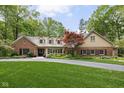 Beautifully landscaped home featuring a brick and siding exterior with a lush front lawn and mature trees at 9080 Pickwick Dr, Indianapolis, IN 46260