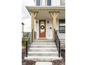 Inviting front entrance featuring a brown door with a wreath, black iron railings, and concrete steps at 11505 Langton Walk, Zionsville, IN 46077