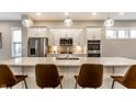 Modern kitchen featuring white cabinetry, quartz countertops, stainless steel appliances, and a large center island with seating at 11505 Langton Walk, Zionsville, IN 46077