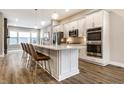 Modern kitchen featuring white cabinetry, quartz countertops, stainless steel appliances, and a large center island with seating at 11505 Langton Walk, Zionsville, IN 46077