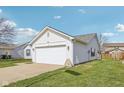 Well-maintained white home with attached two-car garage, lush green lawn and mature landscaping at 1156 E Mill Run Blvd, Greenfield, IN 46140
