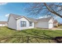 Side view of a well-maintained single-story home with white siding, blue shutters, and a lush green lawn at 1156 E Mill Run Blvd, Greenfield, IN 46140