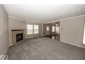 Spacious living room featuring plush carpeting, neutral paint, and a cozy brick fireplace at 11849 Wapiti Way, Noblesville, IN 46060