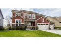 Charming two-story home with well-maintained lawn features a wide driveway and attached two-car garage at 11925 Piney Glade Rd, Noblesville, IN 46060