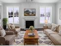 Inviting living room with fireplace, bright windows, cozy seating and stylish rug at 13820 N Honey Creek Dr, Camby, IN 46113