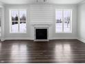 Bright living room featuring modern fireplace, dark hardwood floors and windows overlooking outdoors at 13820 N Honey Creek Dr, Camby, IN 46113