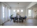 Elegant dining room featuring modern chandelier, large windows, and light hardwood floors at 13947 Morningtide Cir, Fishers, IN 46038