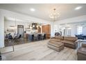 Bright, open-concept living area with hardwood floors, modern lighting, and seamless kitchen access at 13947 Morningtide Cir, Fishers, IN 46038