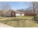 Single-story house with a brick accent wall, neutral siding, and a well-kept lawn, showcasing the home's curb appeal at 1405 Creekside Dr, Brownsburg, IN 46112