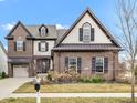 Beautiful two-story brick home featuring a two-car garage and well-maintained front yard with professional landscaping at 1521 Avondale Dr, Westfield, IN 46074