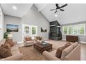 Bright living room with vaulted ceilings, a stone fireplace, neutral furniture, and light wood floors at 1641 Whistler Terrace, Indianapolis, IN 46229