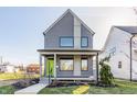Charming two-story home with a modern design, featuring gray siding, a cozy front porch, and a well-maintained lawn at 1955 Alvord St, Indianapolis, IN 46202