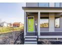 Inviting porch with a vibrant green door, complemented by dark trim, modern windows, and easy access at 1955 Alvord St, Indianapolis, IN 46202