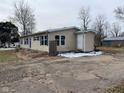 Single-story home with tan siding, green shutters, and a cracked driveway at 209 Crawford St, Clayton, IN 46118