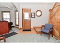 Cozy entryway boasts wood accents, a staircase, and a comfortable seating area at 32 E Main St, Mooresville, IN 46158