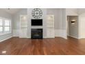 Comfortable living room featuring a fireplace, custom built-ins, and stylish hardwood floors at 3792 Waterfront Way, Plainfield, IN 46168