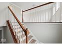 Interior staircase showing wooden handrail and white balusters, and updated flooring at 4448 Aristocrat Cir, Indianapolis, IN 46235