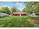 A single-Gathering home with verdant green grass, mature trees, and blue skies creating a picturesque scene at 4754 E 64Th St, Indianapolis, IN 46220