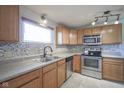 Kitchen with stainless steel appliances, wooden cabinets, mosaic tile backsplash, and tile flooring at 5415 Wallace Ave, Indianapolis, IN 46220