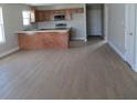 Kitchen and living area with eat-in island, LVP flooring and wood cabinets at 769 E Pearl St, Whiteland, IN 46184