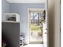 View through the front door onto the front yard, showcasing a tiled entryway with storage and a wreath at 7965 Benjamin Dr, Lawrence, IN 46226