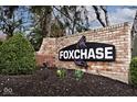 Brick sign for Foxchase community with manicured landscaping, and decorative fox logo at 8077 Foxchase Dr, Indianapolis, IN 46256