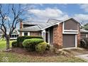 Inviting home showcasing a blend of brick, vinyl siding, an attached garage, and manicured landscaping at 8077 Foxchase Dr, Indianapolis, IN 46256