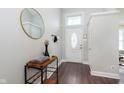 Welcoming entryway with wood flooring, a round mirror, and a decorative console table at 9011 Harrison Run Dr, Indianapolis, IN 46256