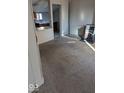 Neutral carpet leads from the living room, which has a free-standing fireplace, toward the kitchen at 9278 S Geneva Rd, Flat Rock, IN 47234