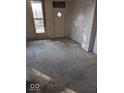 Empty living room with neutral carpet, a window with a view and some damage to the walls and trim at 9278 S Geneva Rd, Flat Rock, IN 47234